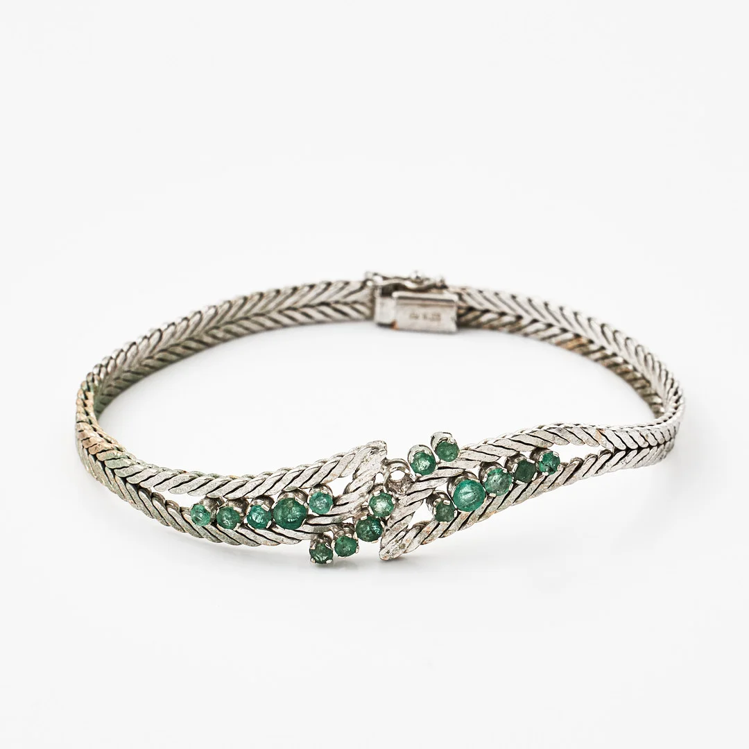 ARMBAND, 18 k rodierat och blankslipat vitguld, mittparti med dekor av 16 fasettslipade smaragder, Vicenz/Italien, 1960-tal. — Bracelets — Stockholms Auktionsverk Magasin 5