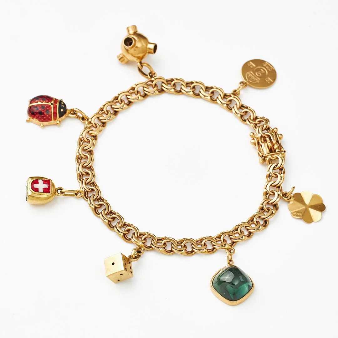 ARMBAND, 18 k guld, Bismarck, 7 berlcoker bl a föreställande nyckelpiga med emaljdekor, satellit, fyrklöver, tärning, GK, Stockholm 1965. — Bracelets — Stockholms Auktionsverk Magasin 5