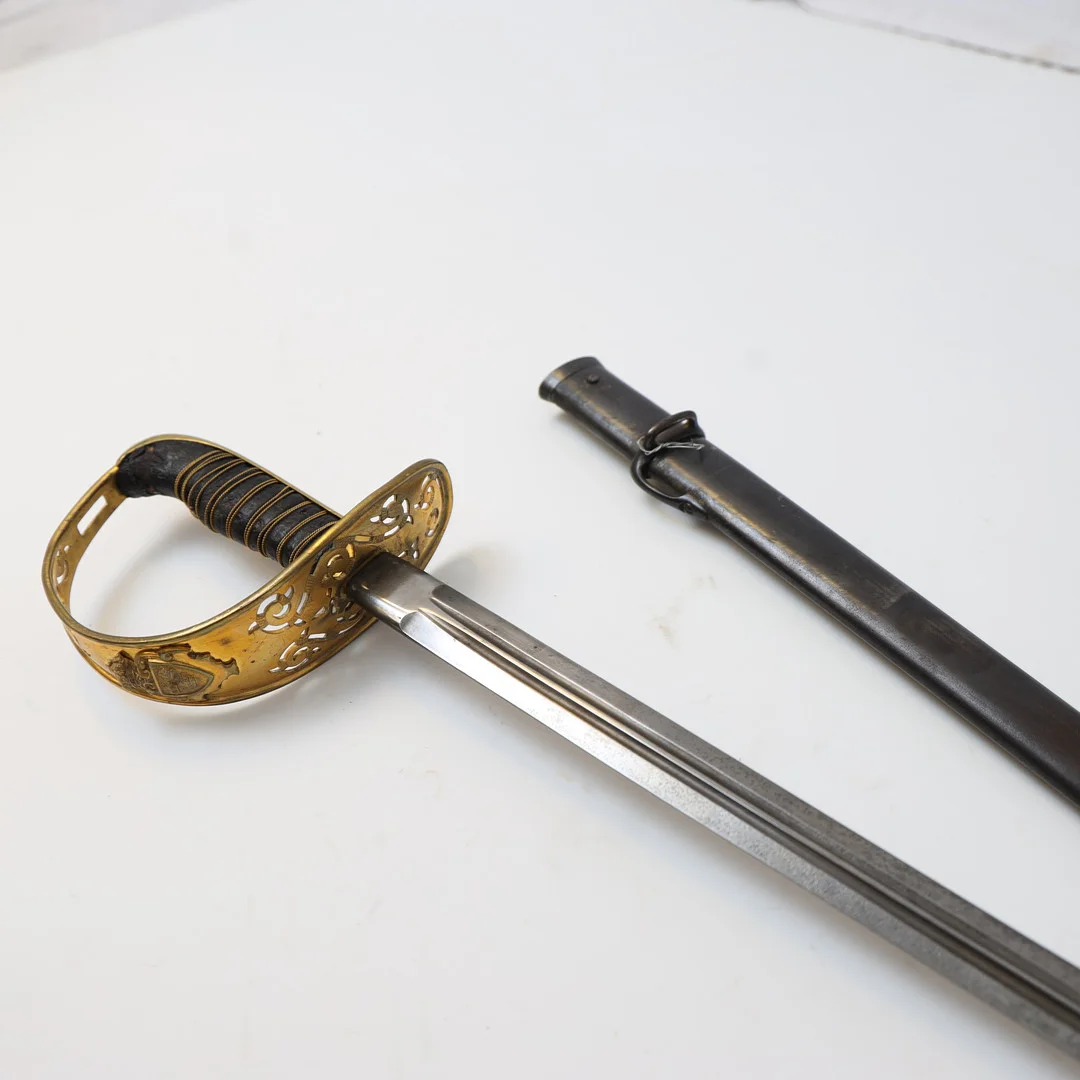 SABEL, svensk, för officer vid kavalleriet, m/1893, klingan märkt E. Svalling Eskilstuna. Lindat handtag, genombrutet parerskydd, balja av svärtat stål. — Edged weapons — Falun Auktionsbyrå