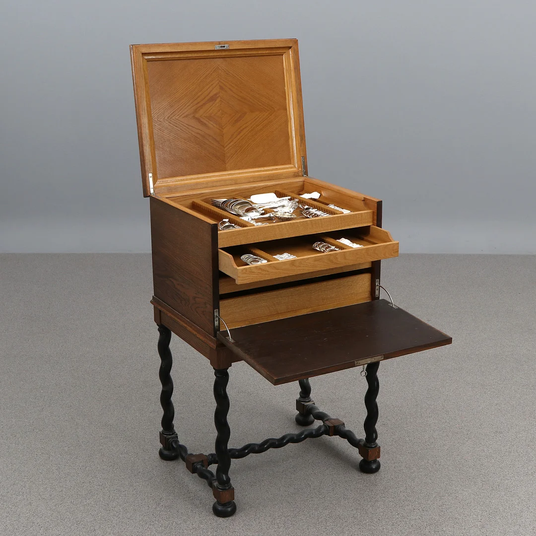 BESTICK I SCHATULL. Silverbestick, modell Olga samt snarlika i ekschatull, barockstil, tidigt 1900-tal. Silvervikt exklusive delar med fyllda skaft ca 1590 gram. — Silver — Skånes Auktionsverk