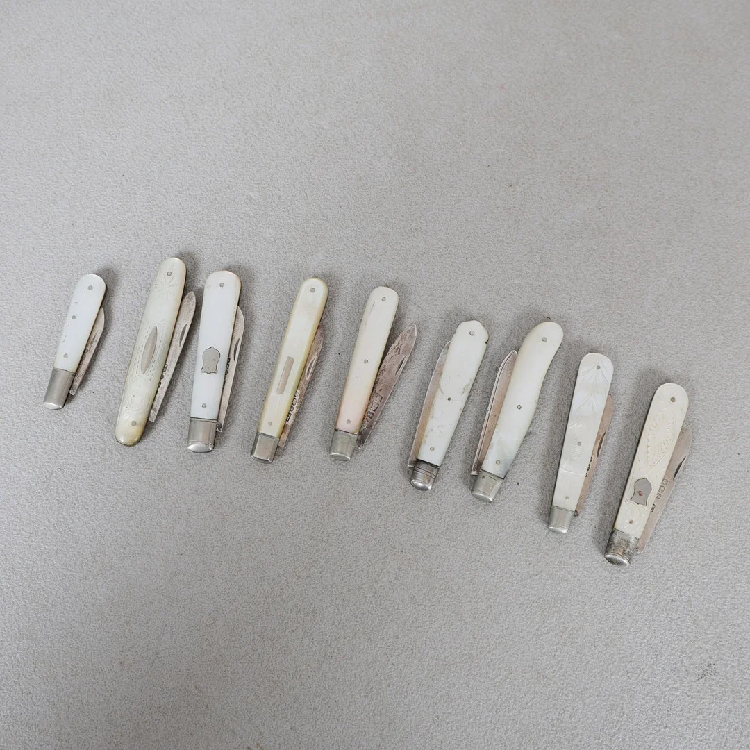 NINE MOTHER OF PEARL AND SILVER HANDLED FRUIT KNIVES (9). — Silver — Bishop & Miller