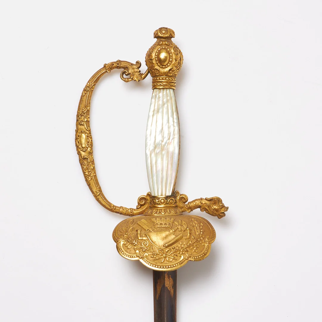 DRÄKTVÄRJA. S.k ämbetsmannavärja, klinga med blånering samt förgylld dekor, kavelplattor i pärlemor, 18/1900-tal. — Edged weapons — Stockholms Auktionsverk Sickla