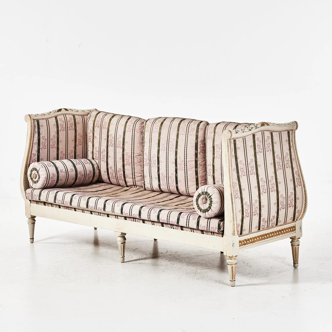 BANKETTSOFFA, gustaviansk-stil, 1800-tal, skuren dekor, bemålad i vitt och guld, lösa ryggkuddar. — Sofas & Seatings — Stockholms Auktionsverk Magasin 5