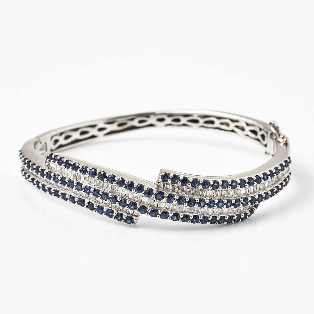 ARMRING, 18 k vitguld, dekor med 50 fasettslipade safirer samt flertalet baguette- och trapetsslipade diamanter, engelska stämplar, Sheffield 2017. — Bracelets — Stockholms Auktionsverk Magasin 5