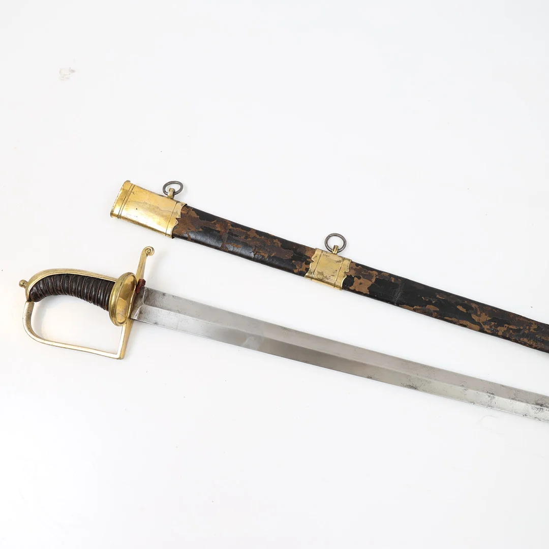 HUGGARE, 1800-tal, lindat handtag med detaljer i mässing, klinga av stål, balja av läder och mässing. — Edged weapons — Falun Auktionsbyrå