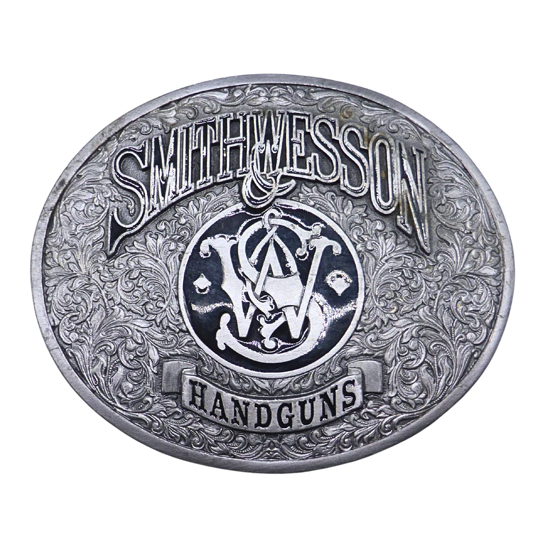 OVALE GÜRTELSCHNALLE MIT SMITH & WESSON HANDGUNS GRAVUR. — Jewellery — Auktionshaus Stuber's Hammerschlag