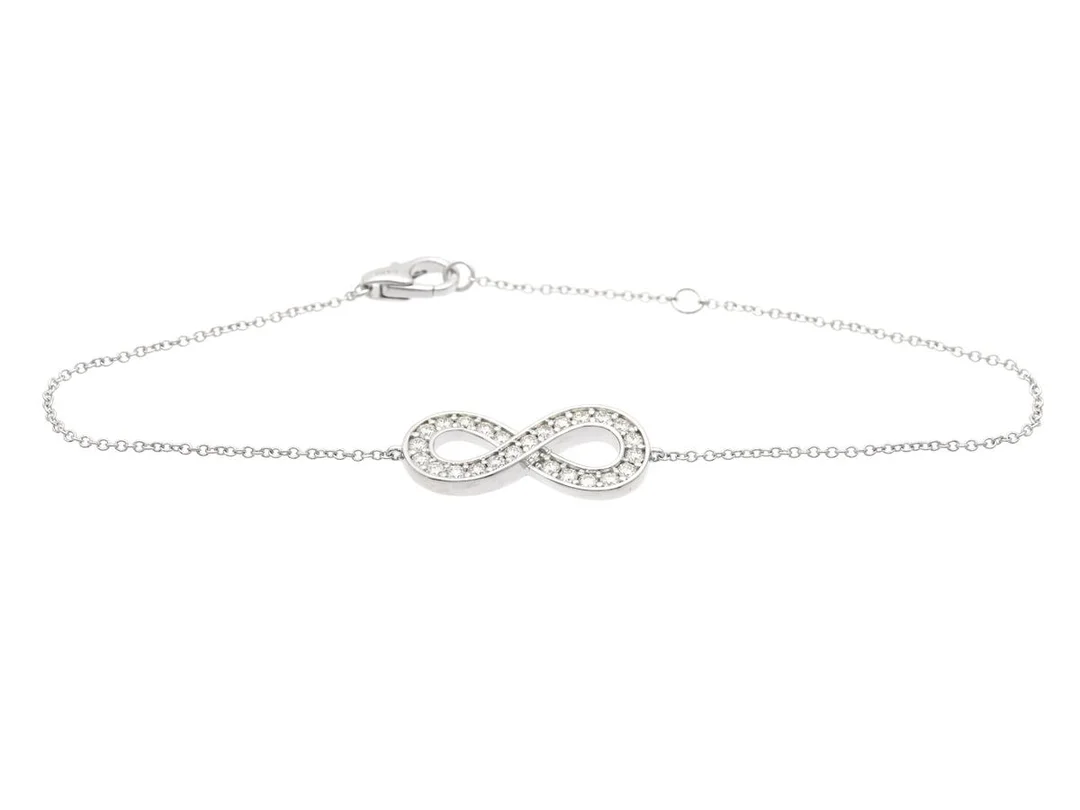 ARMBAND, 18K vitguld, 25 briljantslipade diamanter ca 0,43 ctv, ca W-Cr/VVS-VS, evighetssymbol, längd 16/18 cm, vikt 3,3 g. — Smycken/Armband — Kaplans
