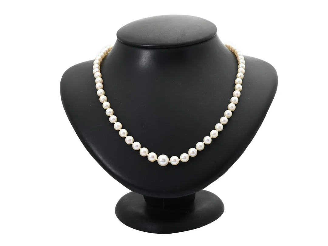 PÄRLCOLLIER, odlade doserade pärlor ca 5-8 mm, längd 54 cm, lås i silver, strass, en av stenarna är skadad, vikt 21,2 g, knutet. — Smycken/Pärlcollier — Kaplans