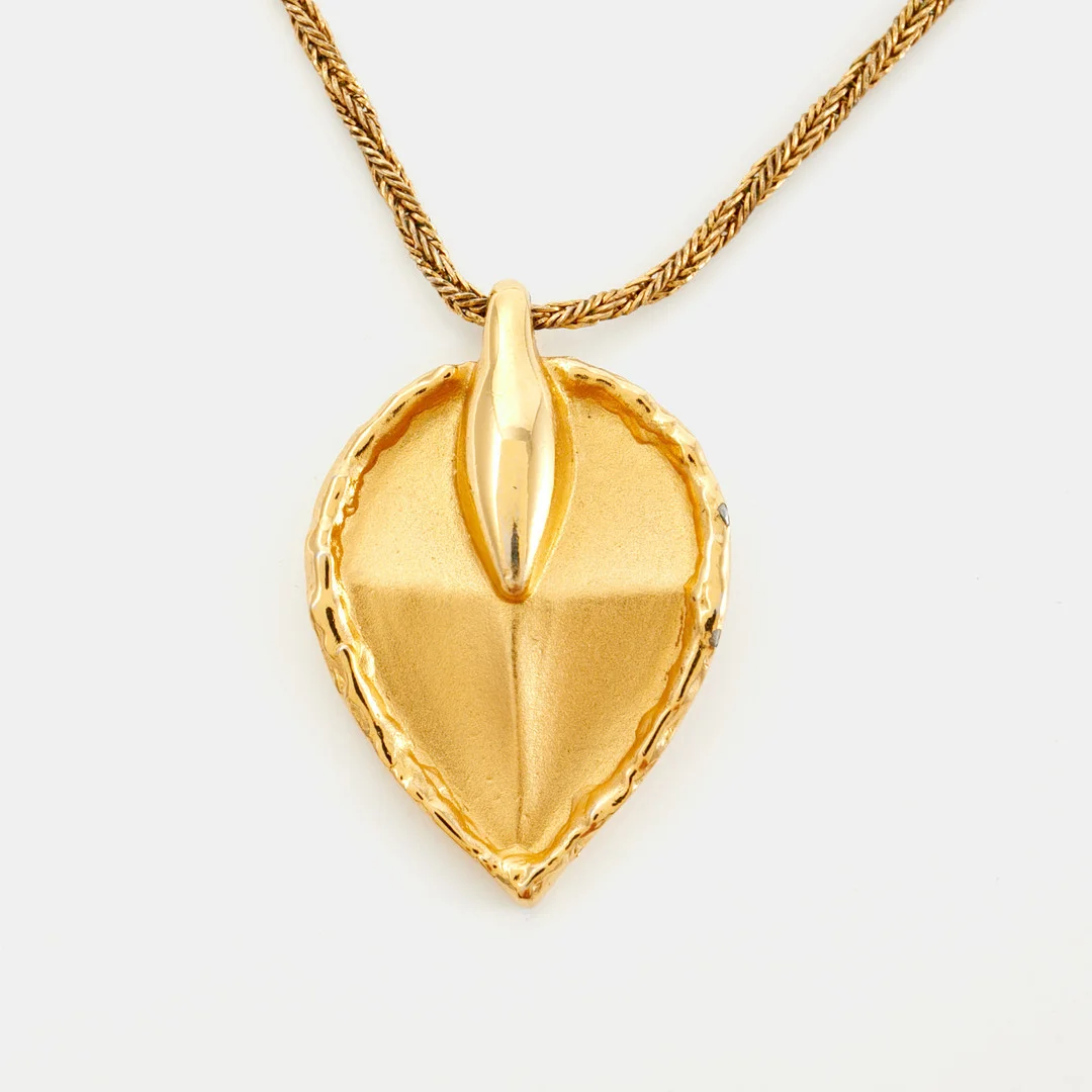 GIVENCHY. Collier, gulmetall, med hänge i form av löv, tvinnad länk, märkt Givenchy Paris New York, 1979. — Necklace — Stockholms Auktionsverk Sickla