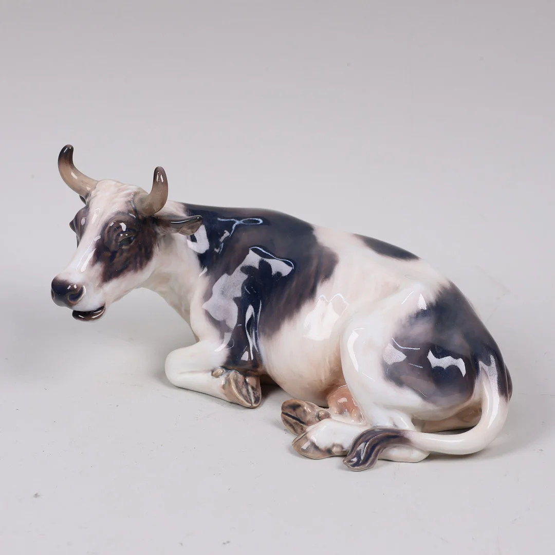 DAHL JENSEN. figurin #1234, liggande ko i porslin, Danmark. — European — Markus Auktioner