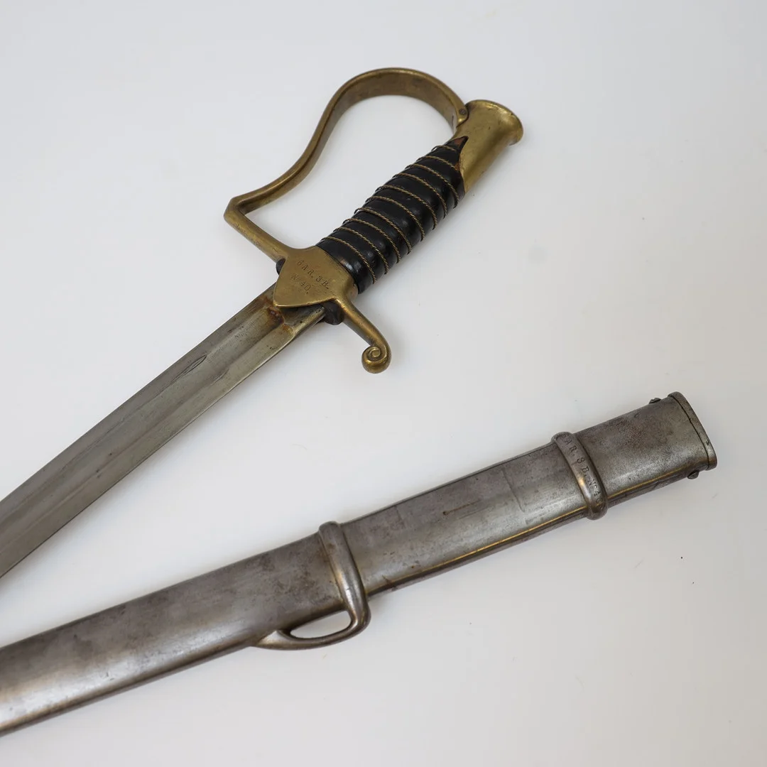 MANSKAPSSABEL. Sverige, M/1889. För kavalleriet. Lindat trähandtag, Detaljer i mässing, klinga och balja av stål. Stämplat. — Edged weapons — Falun Auktionsbyrå