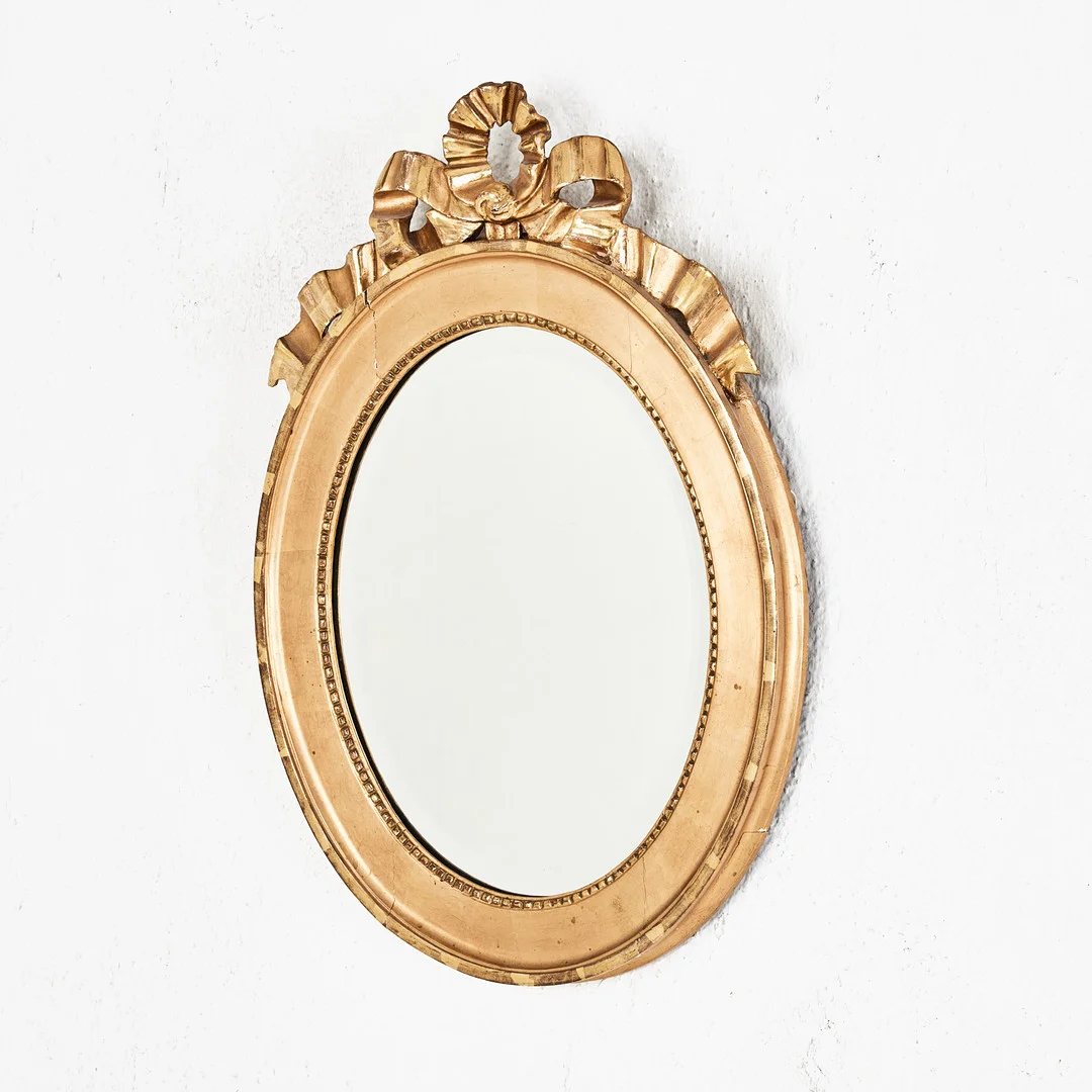 SPEGEL, omkring 1900, gustaviansk stil, förgylld, dekor i pastellage, krön av bandrosett. — Mirrors — Stockholms Auktionsverk Magasin 5