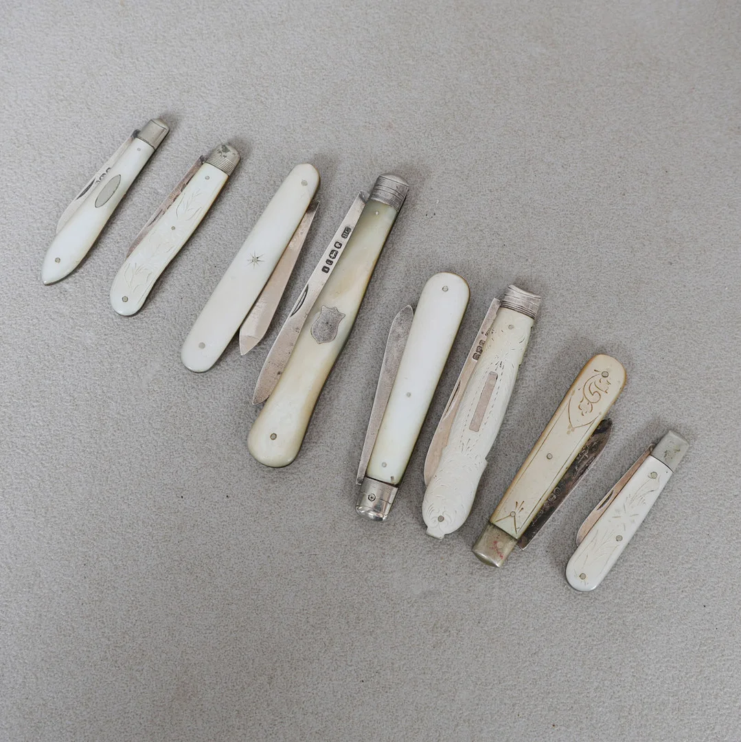 A COLLECTION OF EIGHT MOTHER OF PEARL AND SILVER BLADED FRUIT KNIVES (8). — Silver — Bishop & Miller