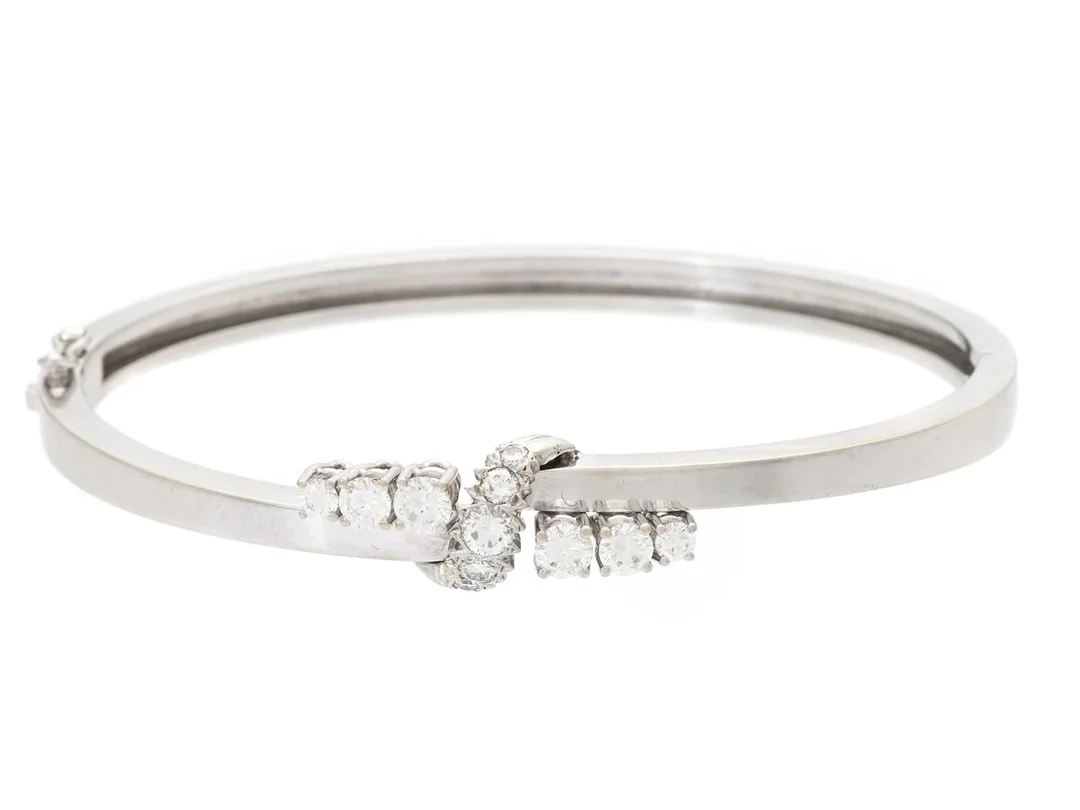 ARMRING, 18k vitguld, 11 briljantslipade diamanter enligt gravyr 0,82 ctv ca W/VS, stel, öppningsbar, ca 57×49 mm, vikt 18,6 g, svensk importstämpel. — Smycken/Armring — Kaplans