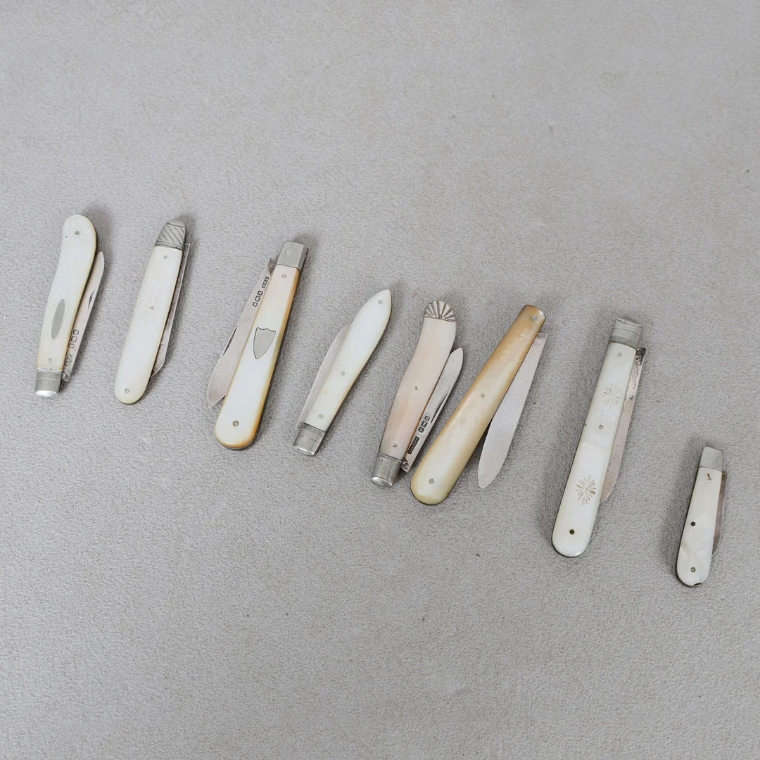 A COLLECTION OF EIGHT MOTHER OF PEARL AND SILVER BLADED FRUIT KNIVES (8). — Silver — Bishop & Miller