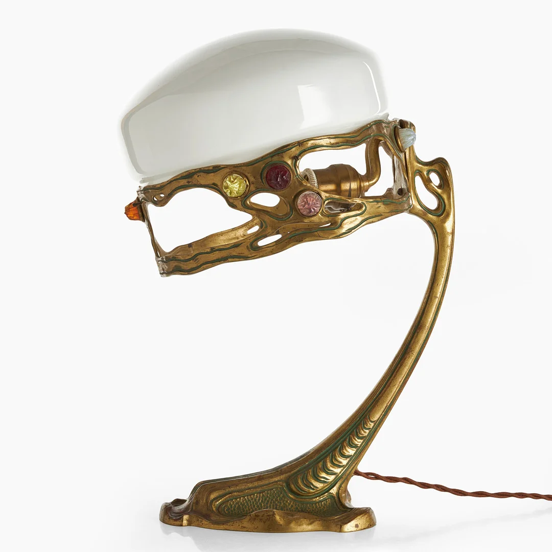 BORDSLAMPA, jugend, tidigt 1900-tal, Fot i brons med infällda glasstenar, senare kupa i vitt opalglas. — Table Lamps — Crafoord Auktioner Stockholm