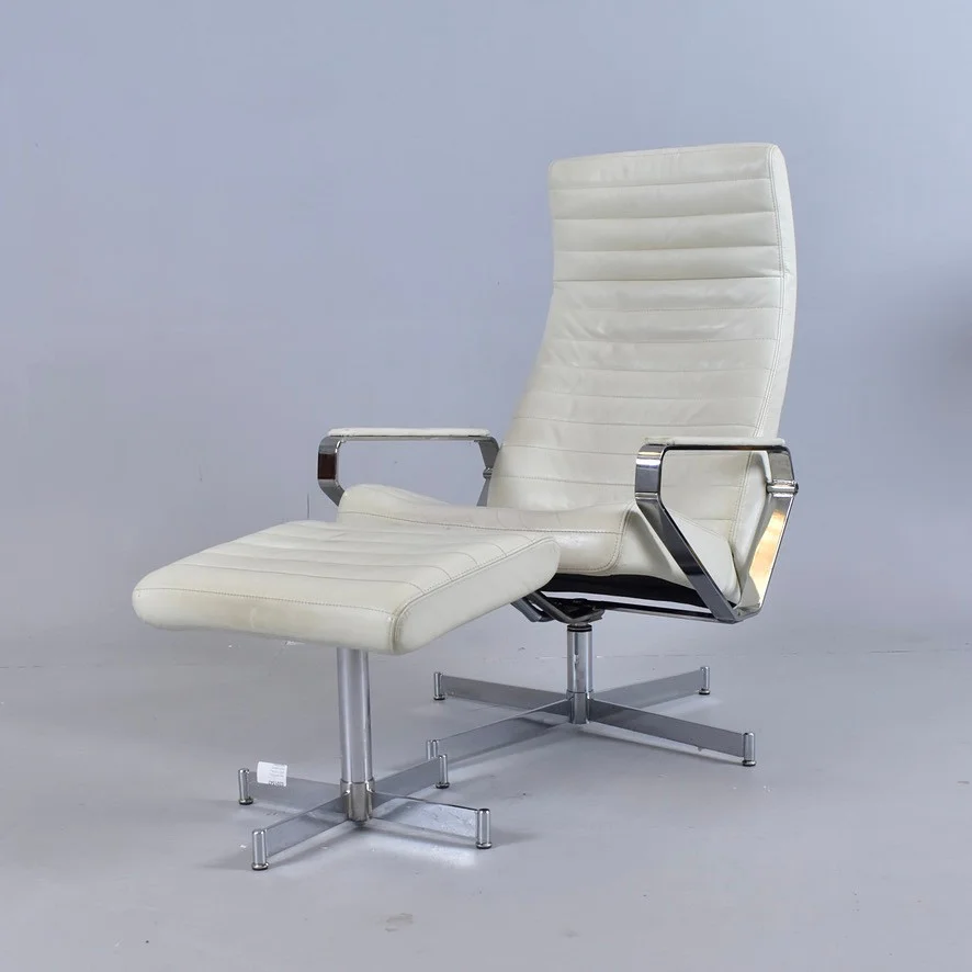 SNURRFÅTÖLJ MED FOTPALL, krom med vit läderklädsel, Bolia Vitesse. — Armchairs & Chairs — Halmstads Auktionskammare