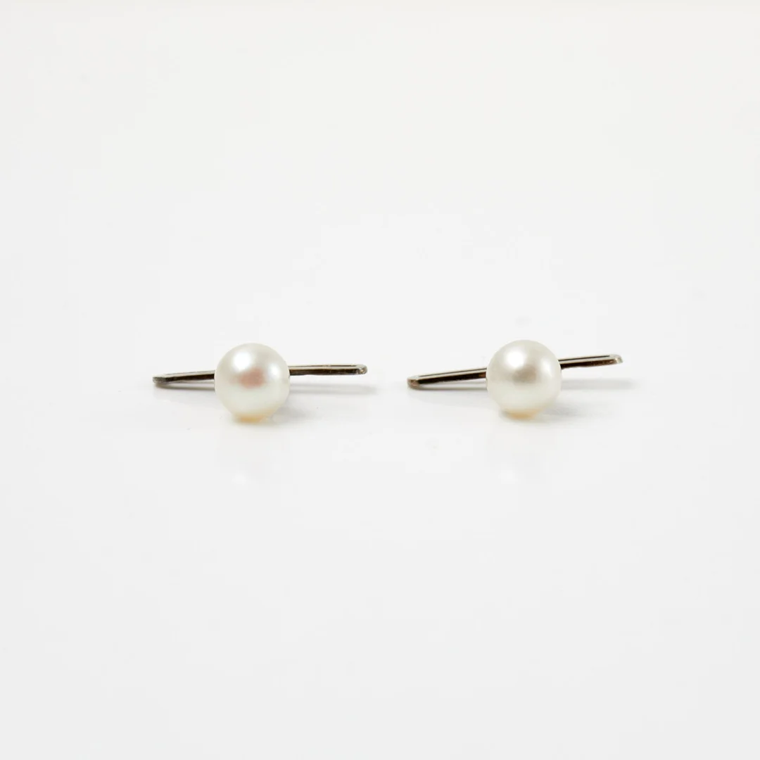 MANSCHETTKNAPPAR, 18 k vitguld, med en odlad saltvattenspärla var, ca 6,5-6,6 mm, Guldvaruaktiebolaget G. Dahlgren & Co Ab, Malmö. — Cufflinks & Tie Pins — Stockholms Auktionsverk Sickla