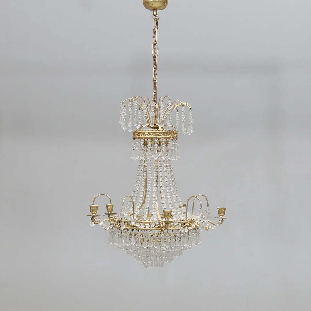 LJUSKRONA, prismor och gulmetall, empirestil, 1900-talets andra hälft. — Chandeliers — Gomér & Andersson Norrköping