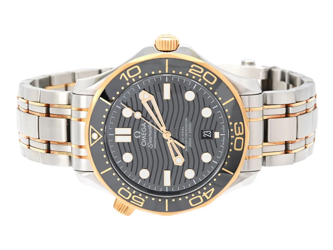 OMEGA, Seamaster Diver, Professional (300m/1000ft), Master Chronometer, Cal 8800, Verk nr. 83025049, Serie nr. 83025049, PIC nr. 210.20.42.20.01.002, herrur, 42 mm, stål/guld, automatisk (Co-Axial), safirglas, datum, svart keramisk bezel, heliumventil, glasbaksida, originallänk, viklås, Ref nr. STZ001159, cert, juli 2022, träbox, ytterkartong. — Klockor/Omega — Kaplans
