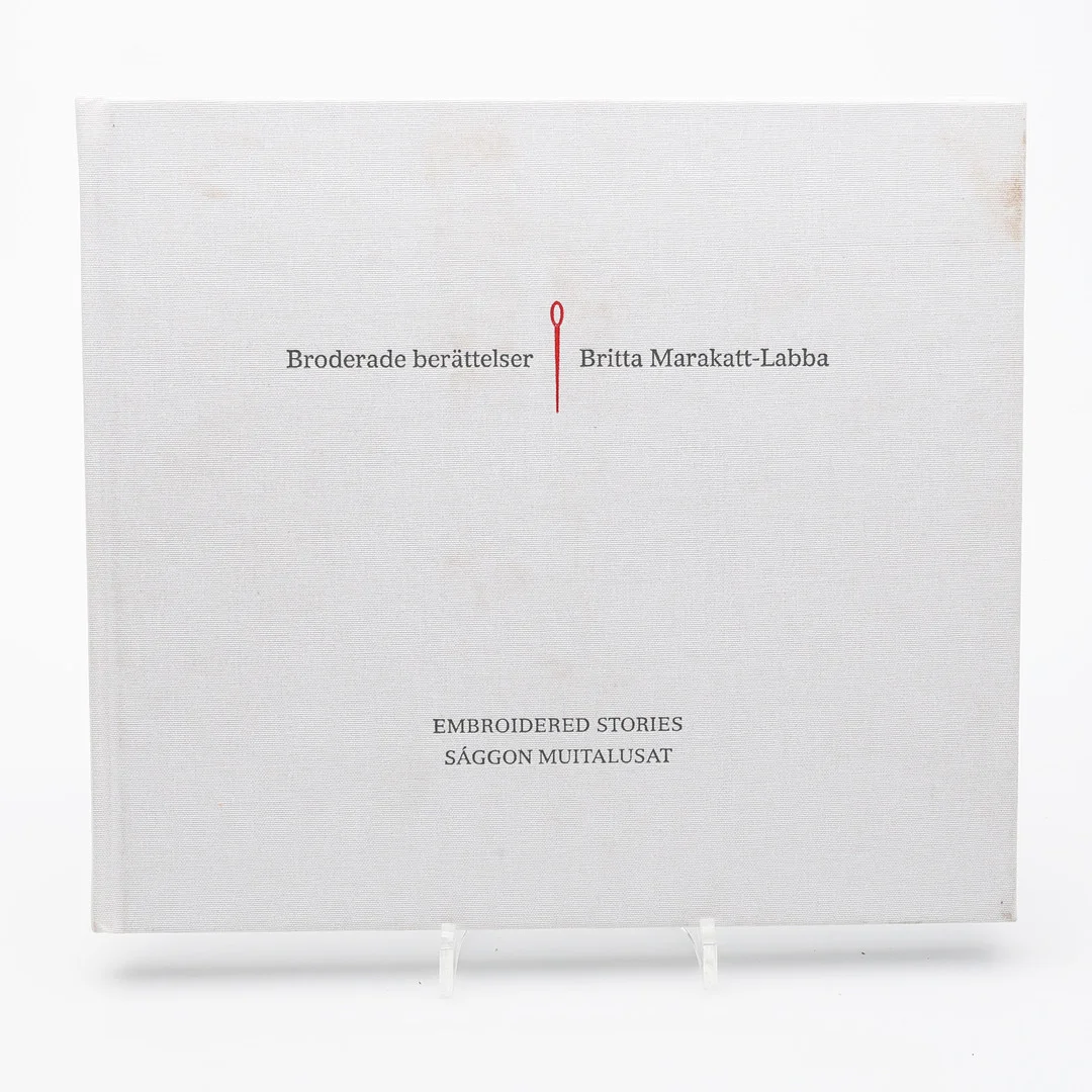 SAMISK KONST. BRODERADE BERÄTTELSE MED BRITTA MARAKATT-LABBAS BRODERIER - 3-SPRÅKIG UTGÅVA 1910. MED EN DEDIKATION FRÅN KONSTNÄREN. — Books — Crafoord Auktioner Lund