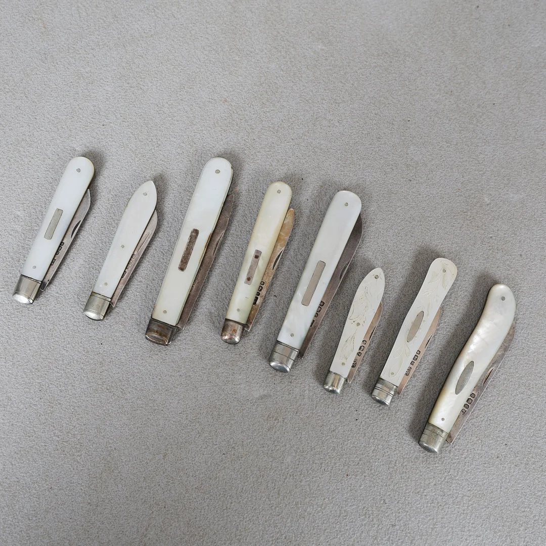 A COLLECTION OF EIGHT MOTHER OF PEARL AND SILVER BLADED FRUIT KNIVES (8). — Silver — Bishop & Miller