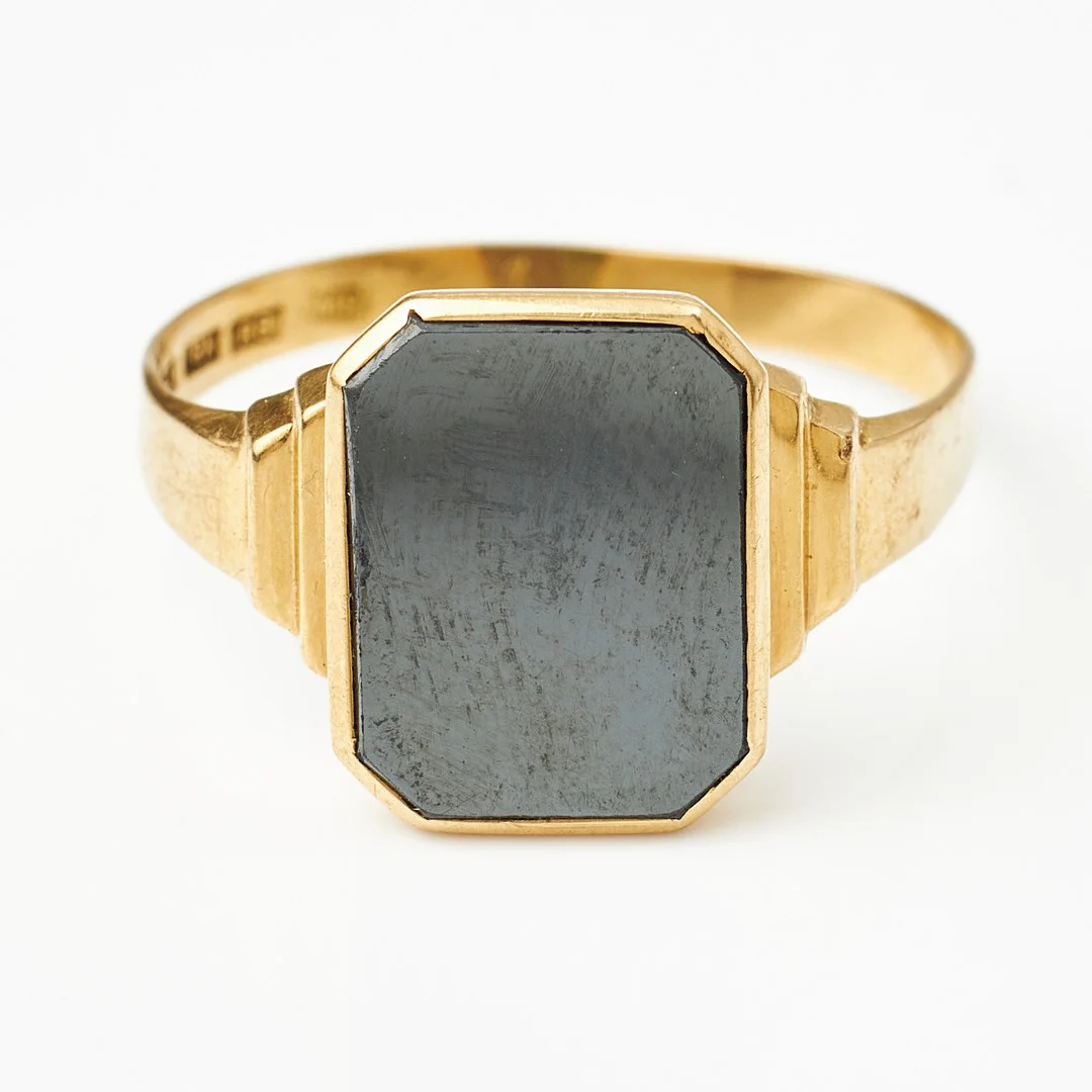 KLACKRING, 18 k guld, planslipad oktagonal hematit, trappslipade sidodekorer, 1943, import, svensk kontrollstämpel. — Rings — Stockholms Auktionsverk Magasin 5