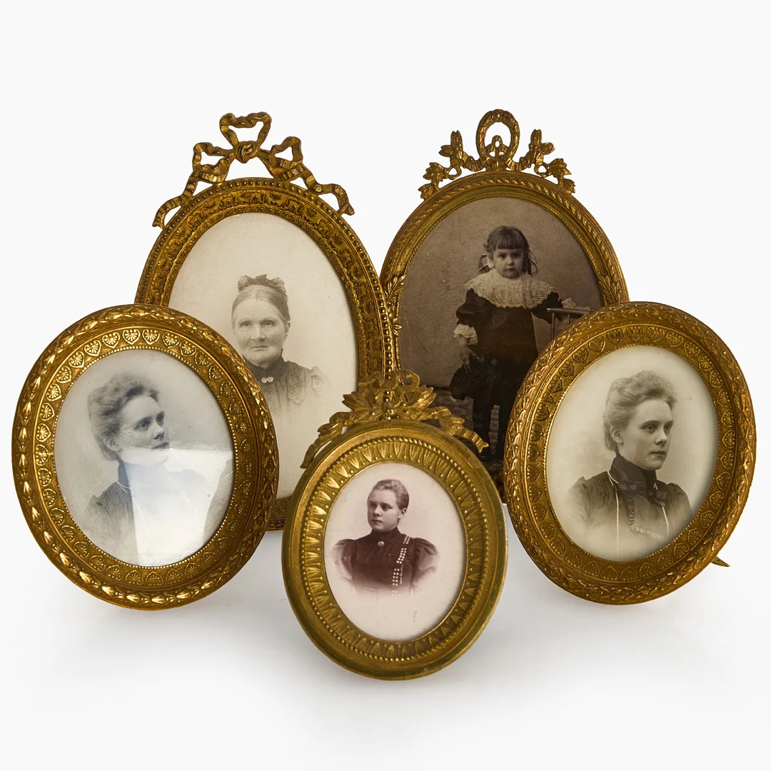 FOTORAMAR, 5 st, förgylld mässing, omkring år 1900, monterade med svartvita fotografier. Empire- resp. Gustaviansk stil. 2 st med tillverkarstämpel "HS". — Pewter, Brass & Copper — Crafoord Auktioner Stockholm