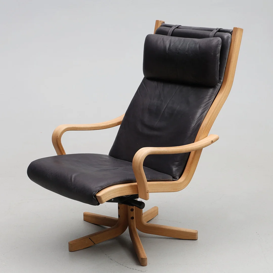 NIELAUS MÖBLER, FÅTÖLJ. Svart skinn med armstöd och ben i formpressad trä. Danmark, samtida tillverkning. — Armchairs & Chairs — Gomér & Andersson Jönköping