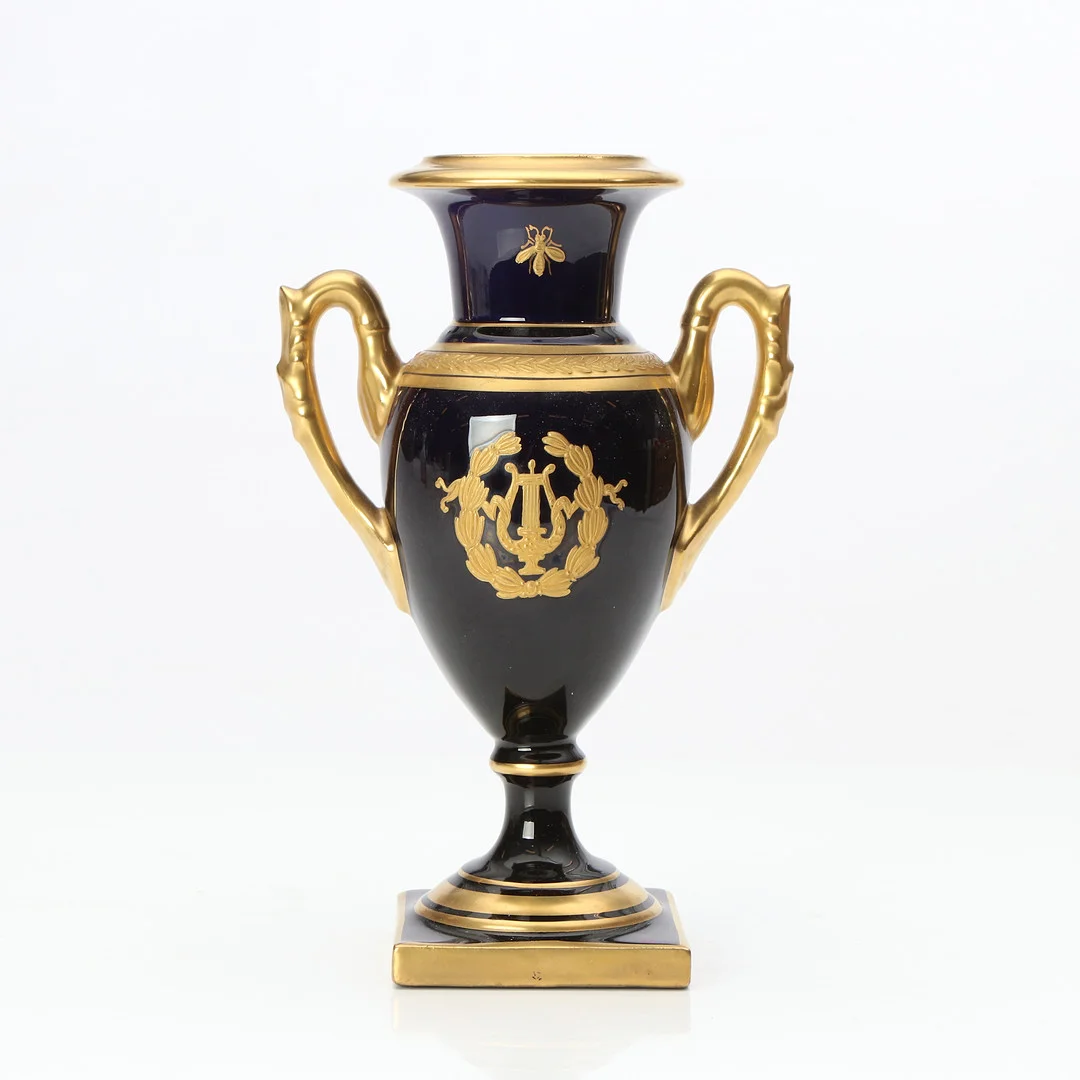 URNA MED HÄNKLAR. Porslin med koboltblå glasyr och gulddekor. St Radeconde. 1900-tal. — European — Skånes Auktionsverk