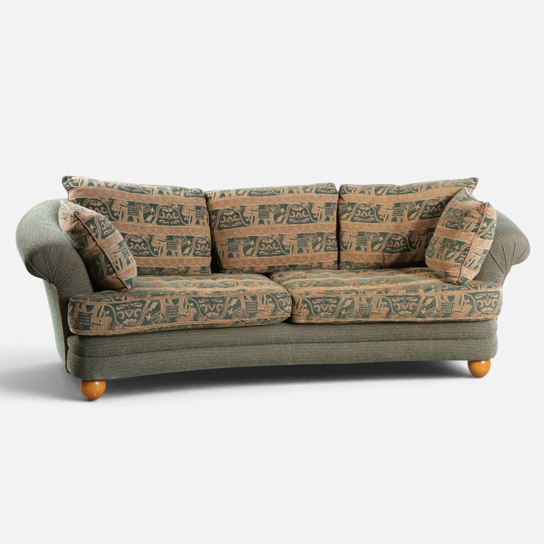 Fritstående tre-pers. sofa betrukket med grønt møbelstof, løse hynder betrukket med dekoreret stof, kugleben bejdset bøg. 20. årh. anden halvdel. — Sofas & Seatings — Woxholt Auktionshus