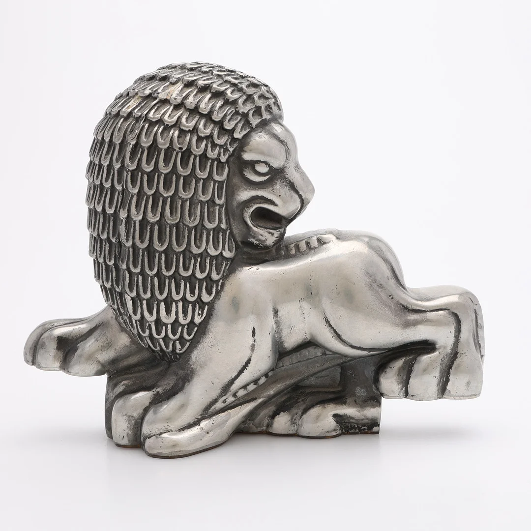 ANNA PETRUS. BOKSTÖD, TENN OCH MÄSSING, UTFORMAT SOM LEJON, FÖR FIRMA SVENSKT TENN, MÄRKT 1978, FORMGIVET UNDER 1920-TAL. — Silver — Crafoord Auktioner Lund