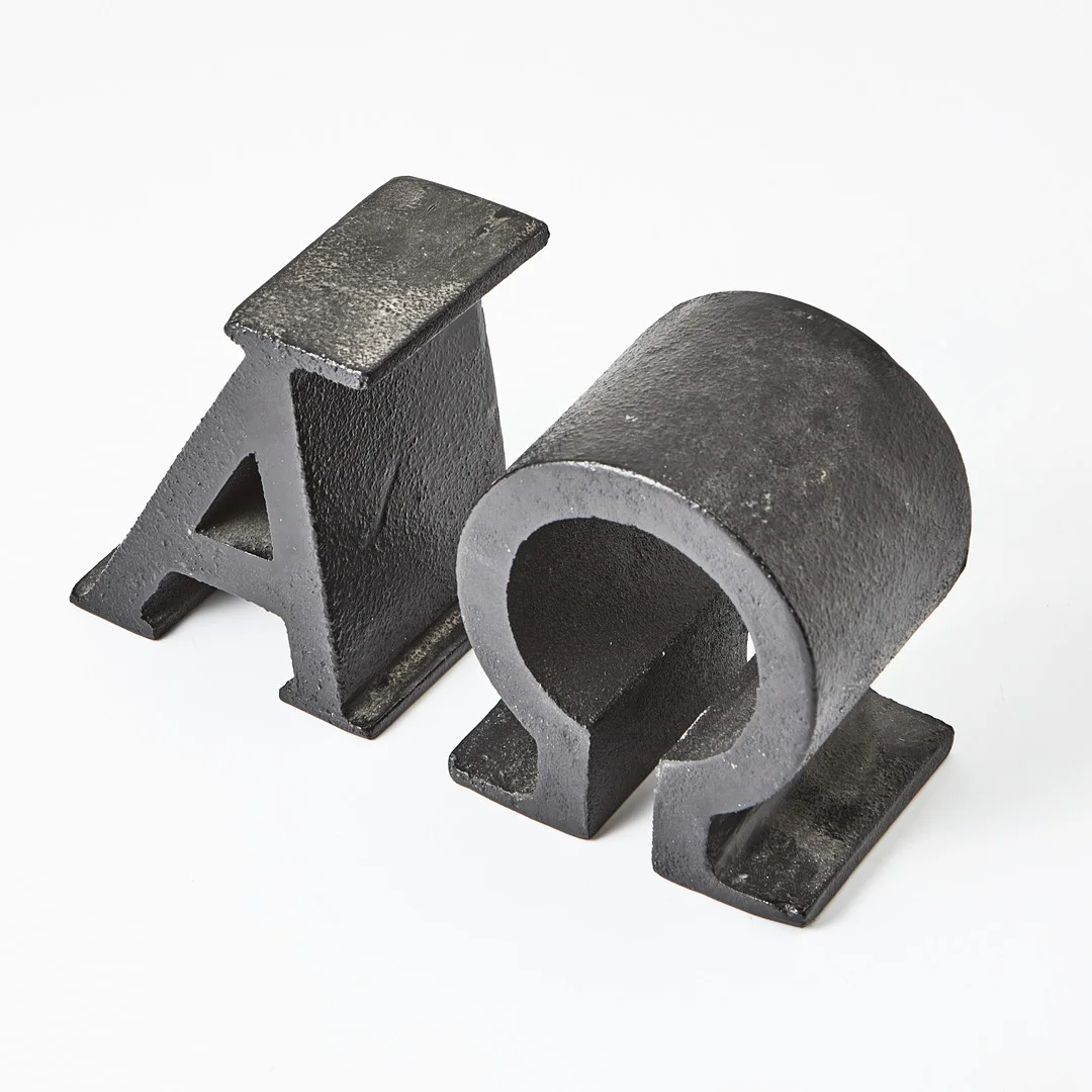 JOSEF FRANK. "Alfa Omega", bokstöd, 1 par, Firma Svenskt Tenn, formgivningsår 1941. — Other metals — Stockholms Auktionsverk Magasin 5