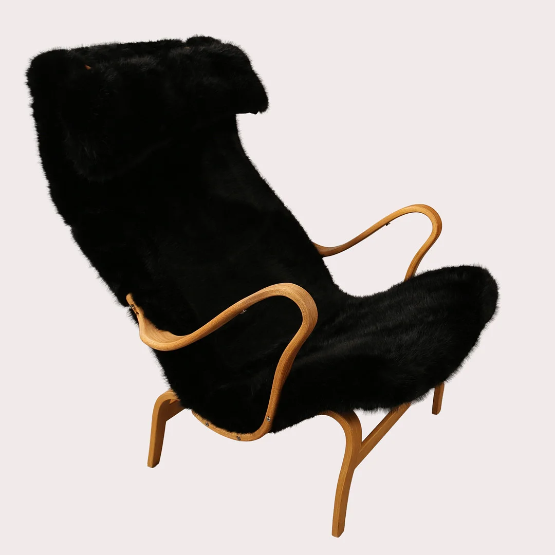 BRUNO MATHSSON. Fåtölj, "Pernilla", stomme i bok med sadelgjord, svart fuskpäls, Bruno Mathsson by Dux. — Armchairs & Chairs — Limhamns Auktionsbyrå