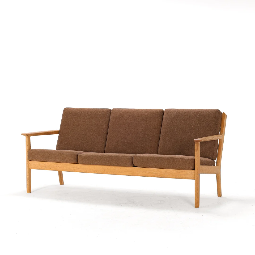 Hans J. Wegner (1914-2007). Three-seater sofa in solid oak, loose cushions upholstered in wool. — Furniture/Lounge suites, sofas — Lauritz