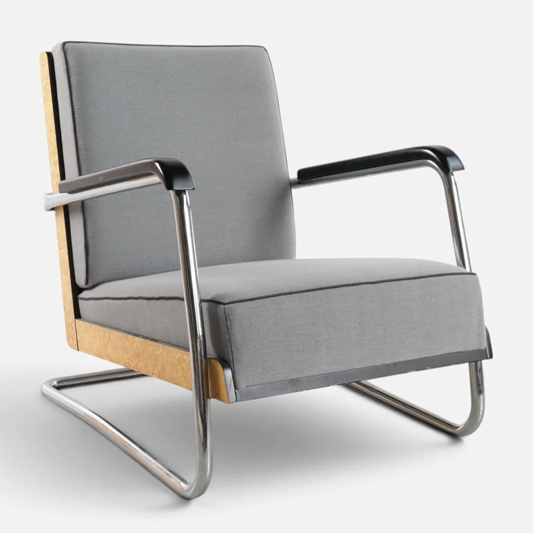 PAULI BLOMSTEDT (1900-1935). Frisvinger lænestol med forkromet stel, sider af Masur birk, betrukket med gråt stof. Udført hos Adelta, model '8160', anden halvdel af det 20. århundrede. — Armchairs & Chairs — Woxholt Auktionshus