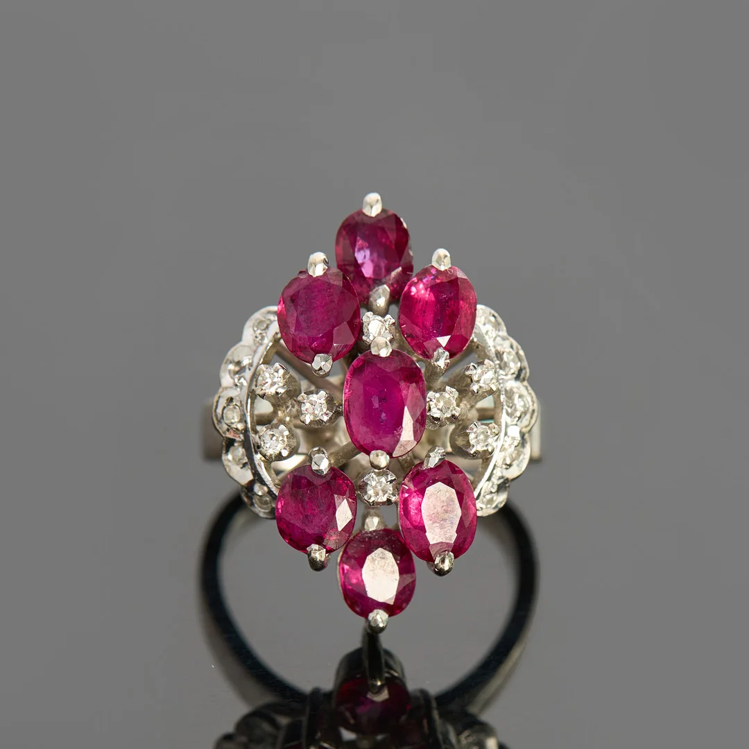 RING, 18k vitguld, navettformad genombruten dekor, dekorerat med 7 st ovalslipade rubiner totalt ca 3.40ct samt 17 st enkelslipade diamanter totalt ca 0.15ct. — Rings — Crafoord Auktioner Stockholm