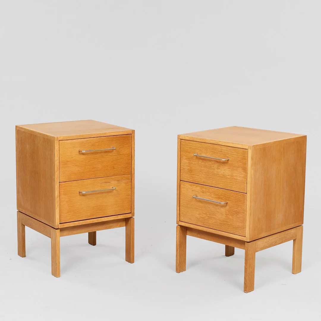 HENNING JENSEN OG TORBEN VALEUR. Et par sengeborde af egetræ, greb af metal, Munch Møbler, Danmark, 1970'erne, (2). — Tables — Palsgaard Kunstauktioner