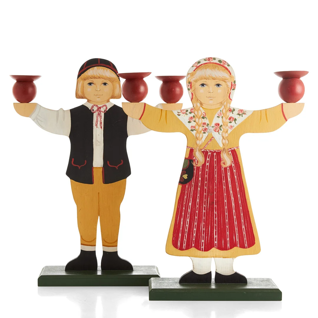 BIRGITTA HEDLUND. Ljusstakar, ett par, bemålat trä, i form av barn i folkdräkter, signerade undertill, 1900/2000-tal. — Candlesticks — Crafoord Auktioner Stockholm