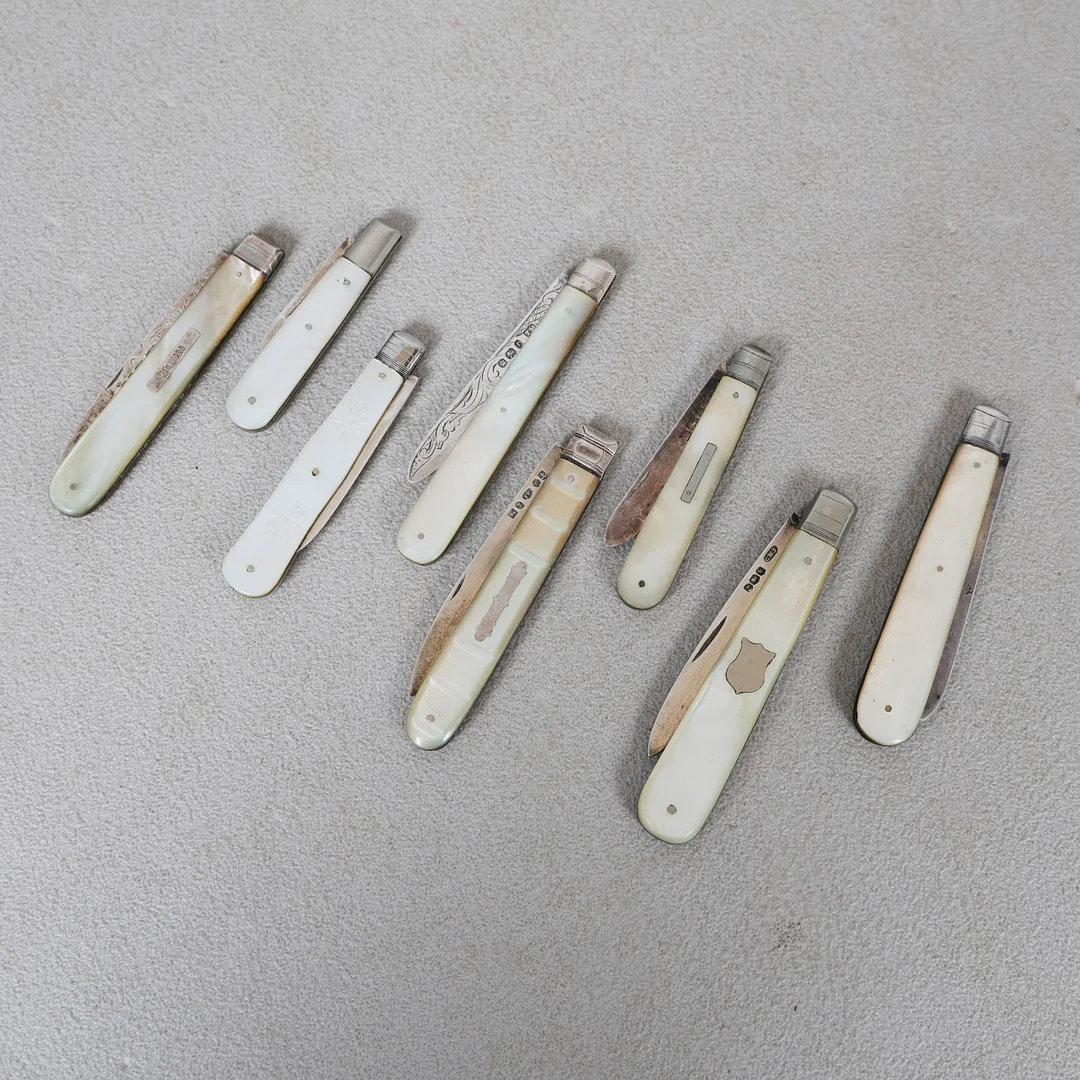 A COLLECTION OF EIGHT MOTHER OF PEARL AND SILVER BLADED FRUIT KNIVES (8). — Silver — Bishop & Miller