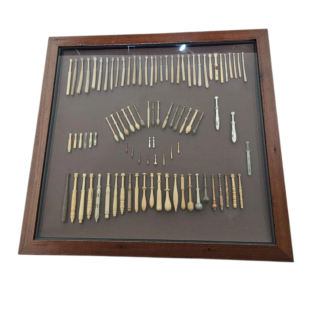 Colección de distintos bolillos enmarcados en un cuadro. — Other — Arce Auctions