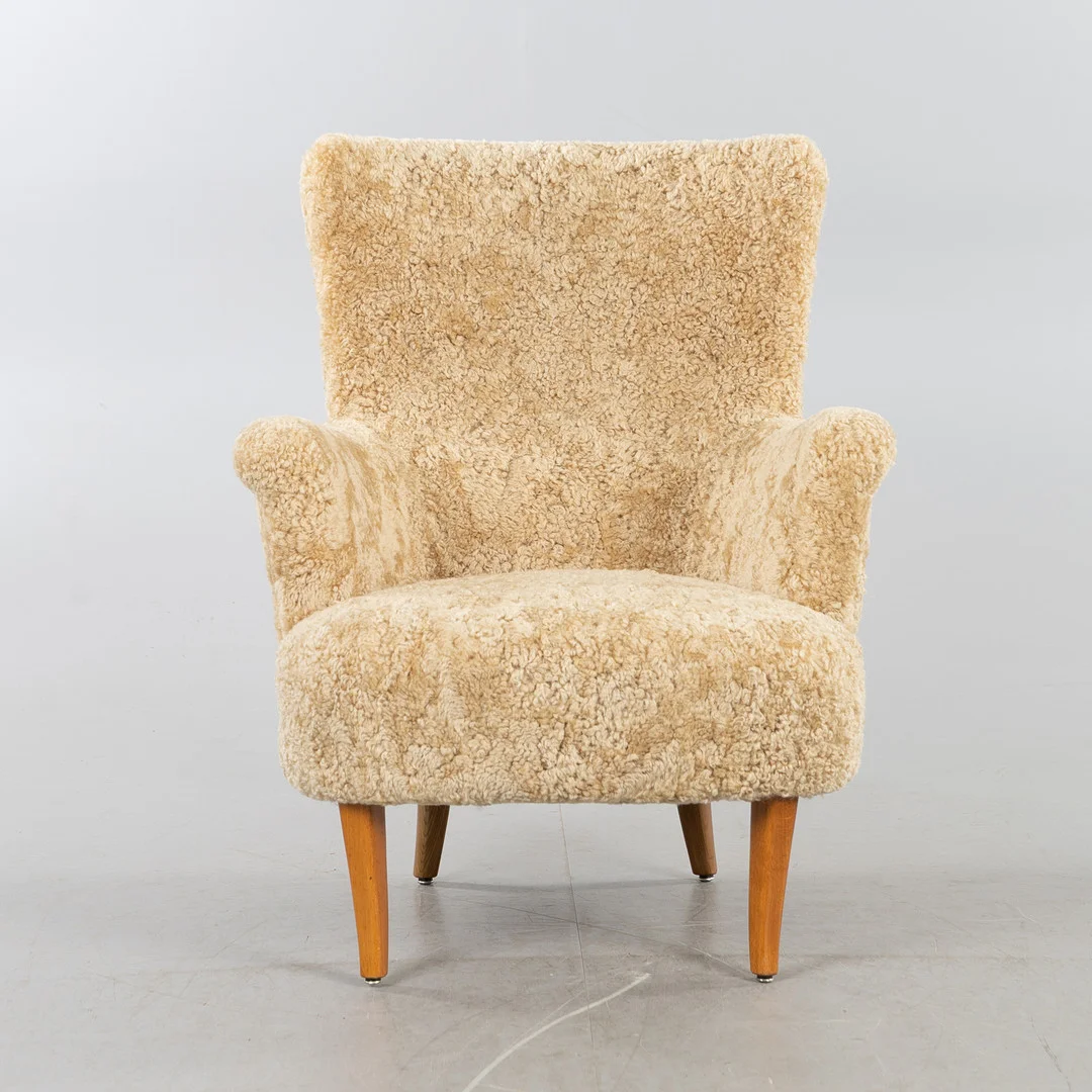 CARL MALMSTEN. Fåtölj "Stora Furulid", AB O.H Sjögren, 1900-talets andra hälft, klädd i fårskinnspäls Honey. — Armchairs & Chairs — Stockholms Auktionsverk Helsingborg