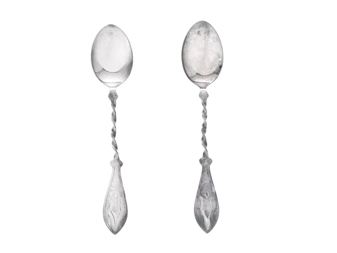 KAFFESKEDAR, 2 st, silver, tvinnad design, Stockholm år 1962, längd 12 cm, vikt ca 16,3 g. — Silver/Matsilver — Kaplans