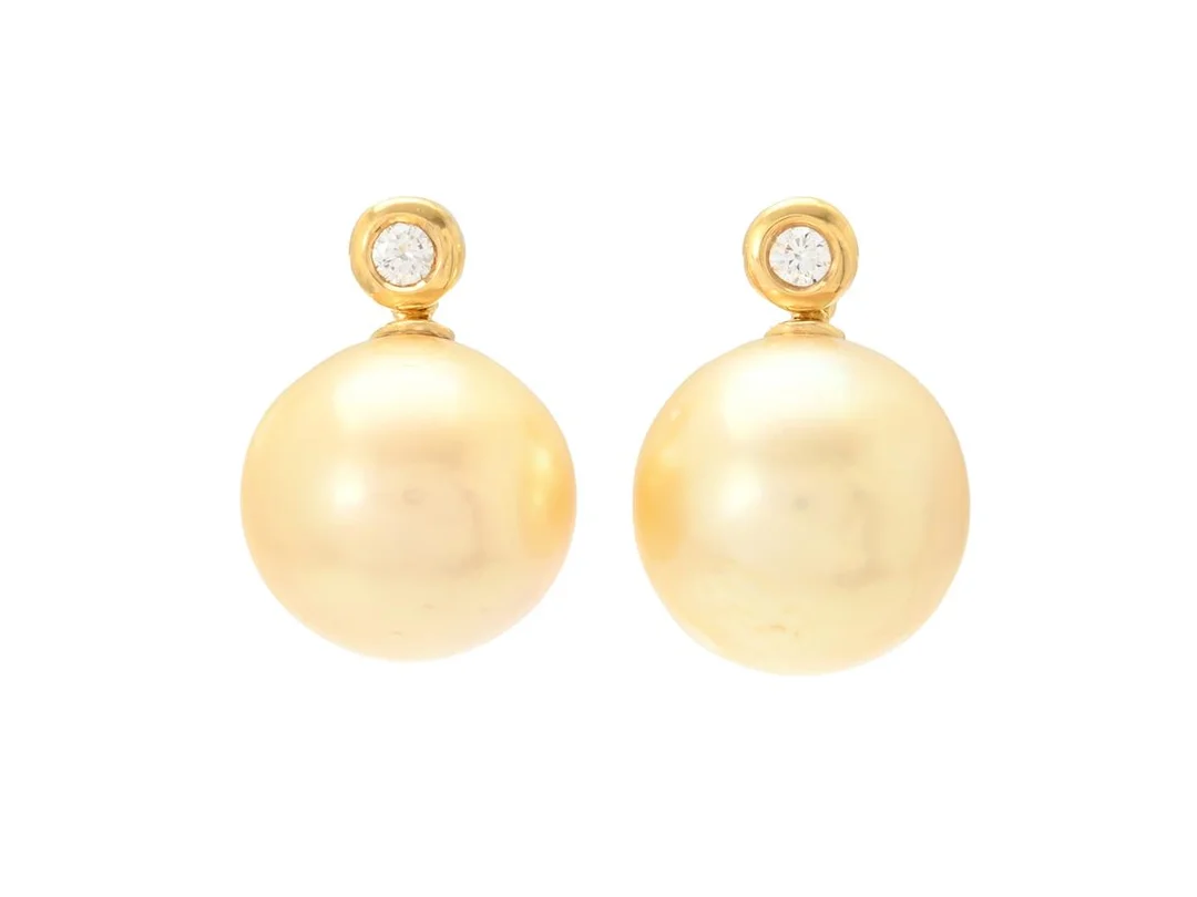 PÄRLÖRHÄNGEN, 18K guld, odlade golden South Sea pärlor ca 14,6 mm, briljantslipade diamanter ca 0,20 ctv, ca TW/VS, höjd 20 mm, vikt 10,9 g, stift. — Smycken/Pärlörhängen — Kaplans