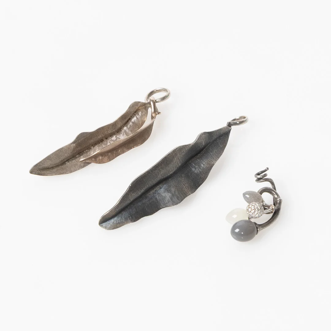 CHARLOTTE LYNGGAARD, hängen, tre stycken, ”Moonlight”, ”Leaves” och ”Dew Drops”, sterlingsilver och 18K vitguld med månstenar, rutilkvarts och briljantslipade diamanter, för Ole Lynggaard. — Brooches & Pendants — Stockholms Auktionsverk Helsingborg