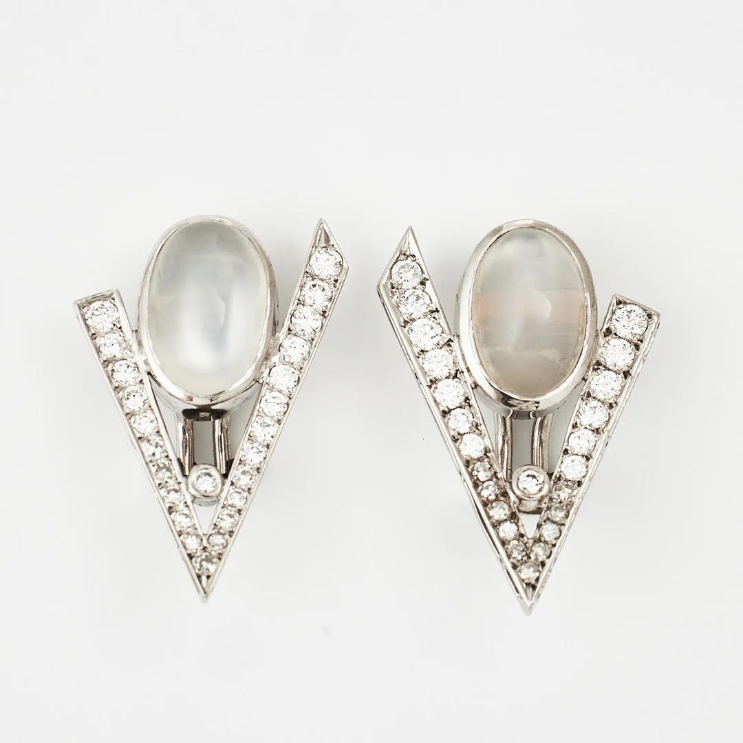 ÖRHÄNGEN/CLIPS, 1 par, 18 k vitguld, cabochonslipade månstenar, dekor med 48 briljanter totalt ca 1,00 ct, KÅ-CE Guldsmedja, Kurt L Carlsson, Stockholm (årsindex saknas). — Earrings — Stockholms Auktionsverk Magasin 5