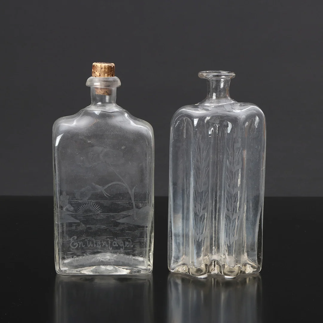 BRÄNNVINSFLASKOR, TVÅ ST. Glas med slipad dekor. Bl.a. Hald. — Utility glass — Skånes Auktionsverk