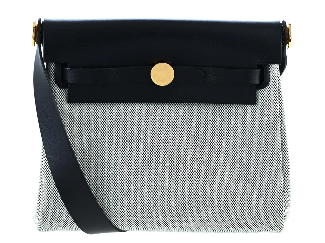 HERMÈS, VÄSKA, Mini Herbag, svart Vache Hunter-läder, ecrufärgad Toile canvas 100% bomull, guldfärgade beslag, 19x15x7 cm, märkt W, år 2024, care booklet, dustbag, originalkartong, plast kvar på beslag. Excellent Condition. — Accessoarer/Väskor — Kaplans