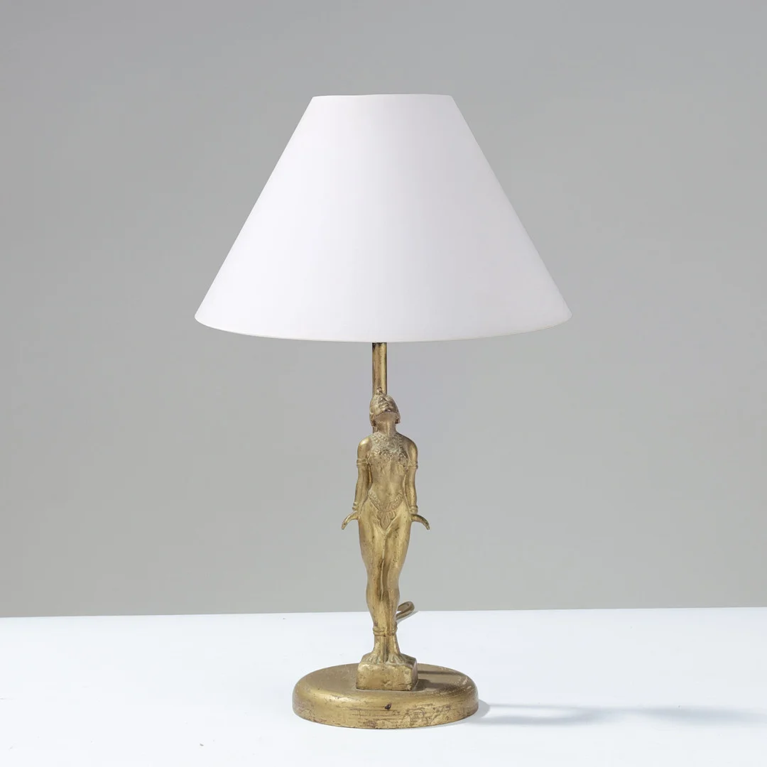 Bordlampe med figur af letpåklædt kvinde i Art Deco stil (muligvis Josephine Baker), fremstillet af guldmalet træ og metal, europæisk lampeproducent, 1930'erne. — Table Lamps — Palsgaard Kunstauktioner