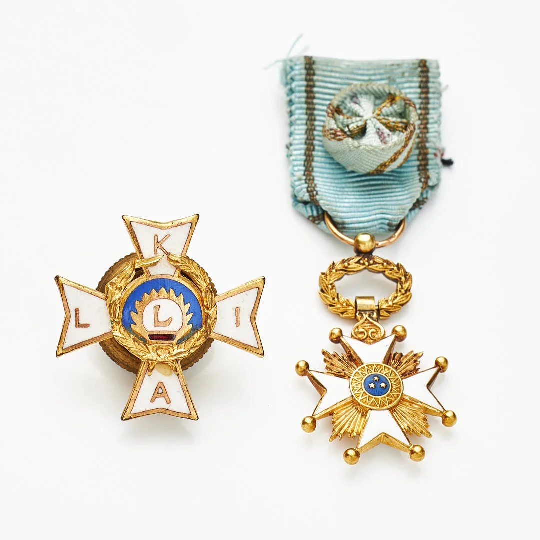 MNIATYRTECKEN, 2 st., Tre Stjärnors orden, 18 k guld, Lettland, resp. Latvian war invalids alliance (LKIA) emigration badge, emaljdekor, oädel metall. — Orders & Medals — Stockholms Auktionsverk Magasin 5